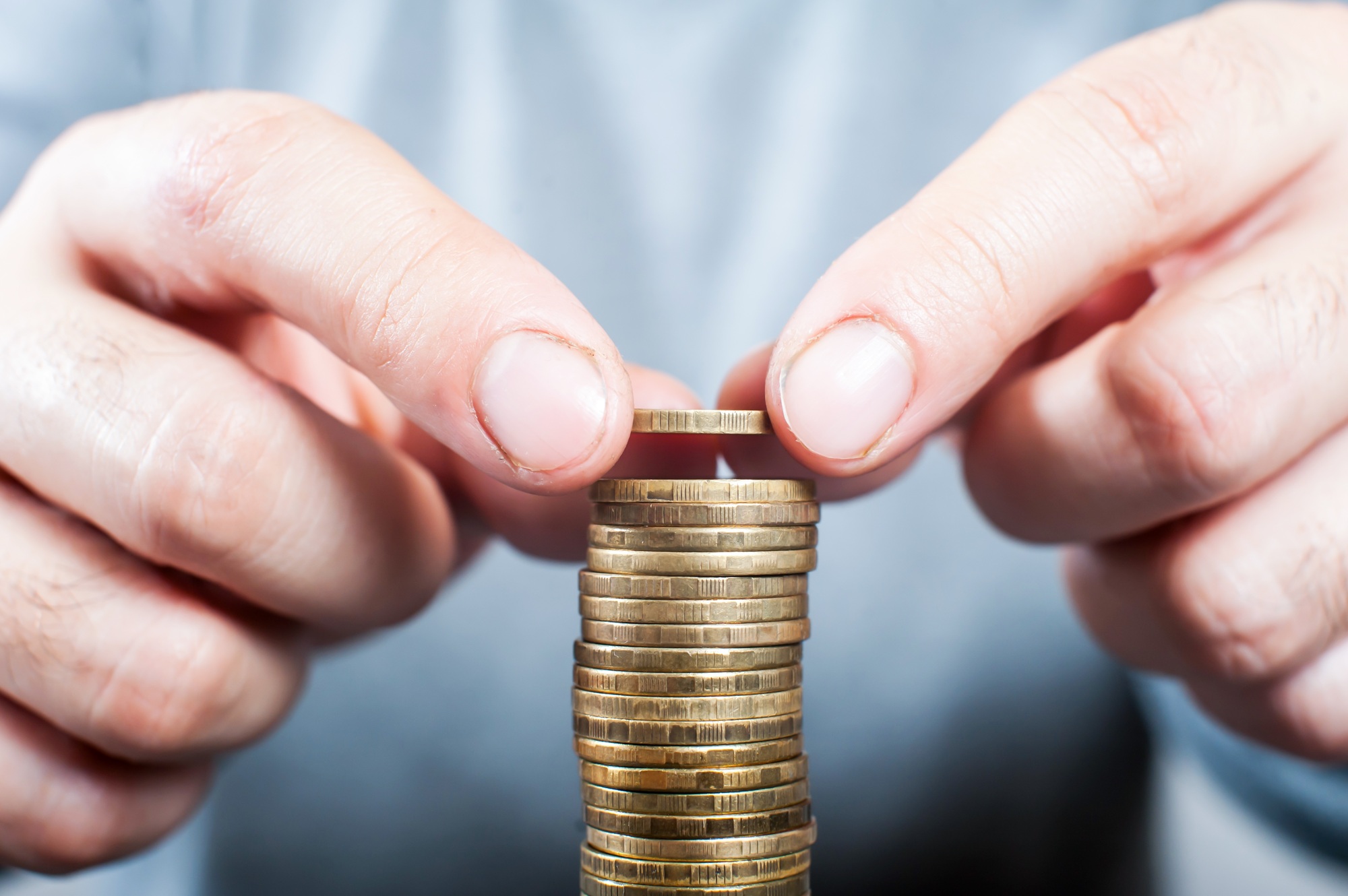 A man stacks coins in a close-up. Economy concept